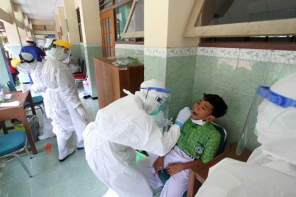 Health workers perform PCR tests in a drive to check all teachers and students at a high school in Solo, Indonesia on Feb. 4, 2022. (AFP file photo)