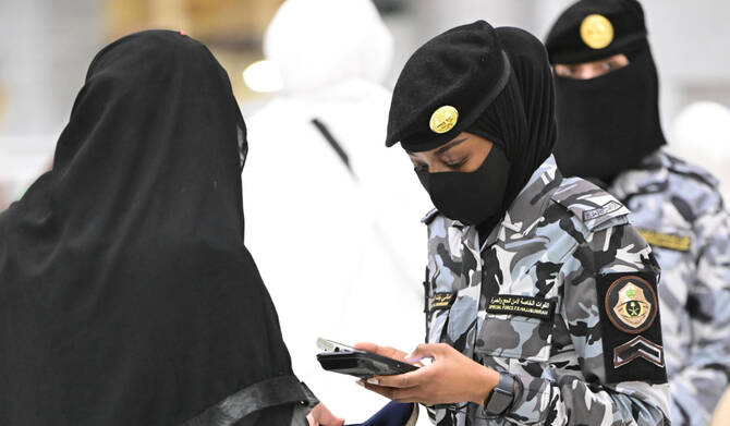 A pilgrim uses the Nusuk app while passing through smart gates at the Grand Mosque. (SPA)