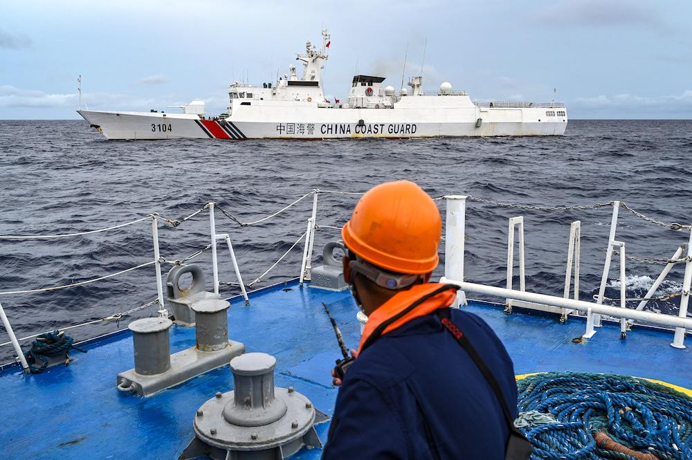 Above, a China Coast Guard ship is seen from the Philippine Coast Guard vessel BRP Cabra during a supply mission to Sabina Shoal in disputed waters of the South China Sea on Aug. 26, 2024. (AFP file photo)