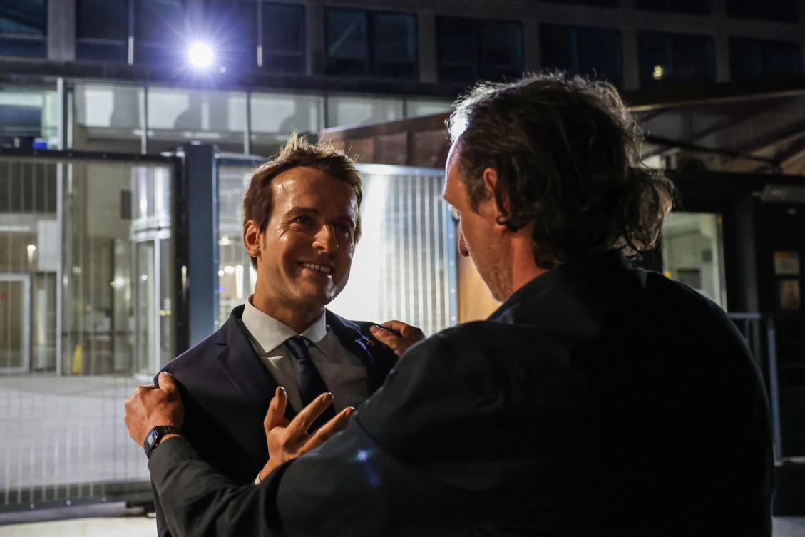 A Greenpeace environmental activist sets up a wax statue of French President Emmanuel Macron, stolen the day before from the Grevin Museum, during an action outside the EDF headquarters in Paris on June 3, 2025. (AFP)