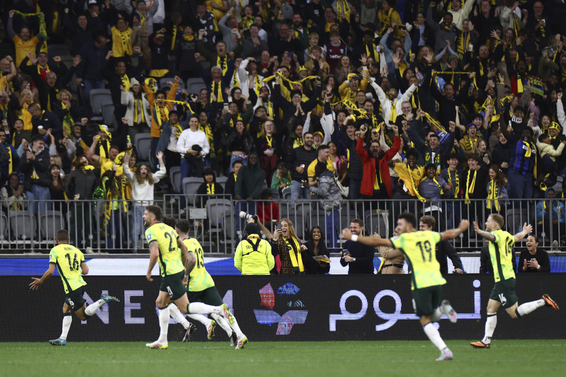 Australia’s Aziz Behich, left, celebrates after scoring against Japan during their World Cup 2026 group C qualifying soccer match in Perth, Jun. 5, 2025. (AP)