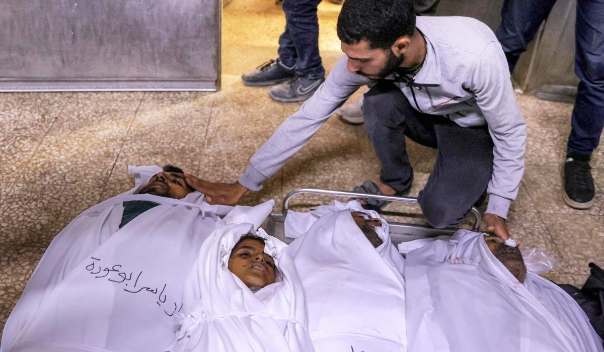 A man bids farewell to the bodies of victims killed during overnight Israeli bombardment lying on the floor at the morgue of al-Shifa hospital in Gaza City on June 4, 2025. (AFP)