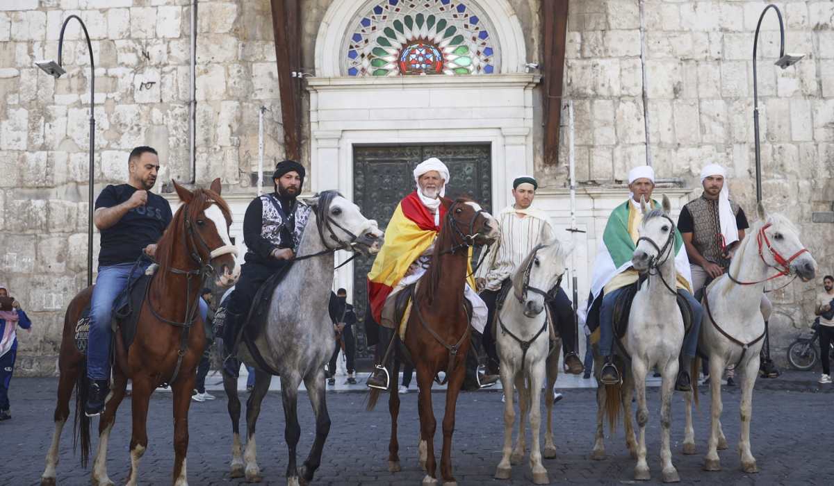 Pilgrims, including three from Spain, pose with their horses outside the Souq al-Hamidiyah market during their months-long horseback journey from Spain to Saudi Arabia to perform the Hajj, in Damascus, Syria, April 21, 2025. (AP)