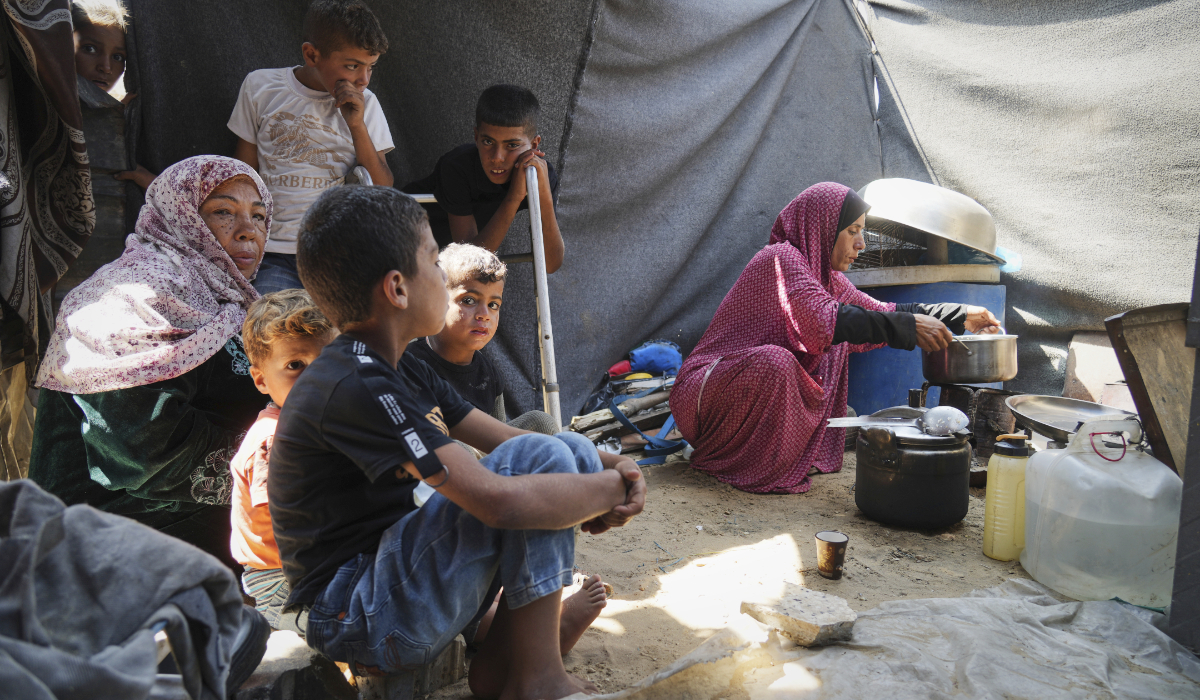 Tahreer Abu Jazar, 36, right, prepares an Eid al-Adha meal for her family inside their tent at a camp for displaced Palestinians in Mawasi Khan Younis, Gaza Strip, on Friday, June 6, 2025. (AP)