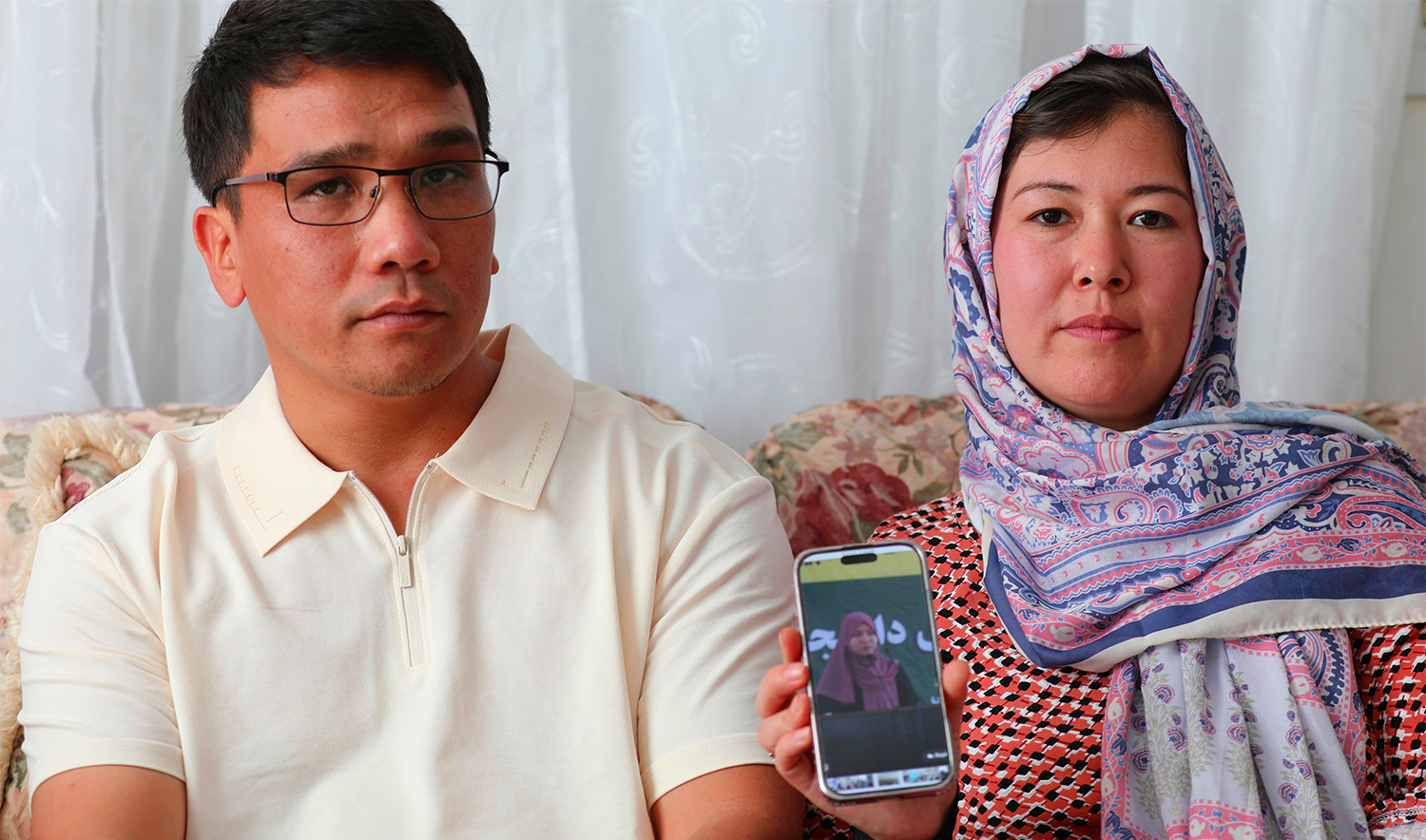 Mohammad Sharafoddin, left, and his wife, Nuriya, right, show a photo of their niece in Afghanistan who won't be able to travel to the U.S., under the new travel ban, during an interview at their home in Irmo, SC, on June 7 2025. (AP)