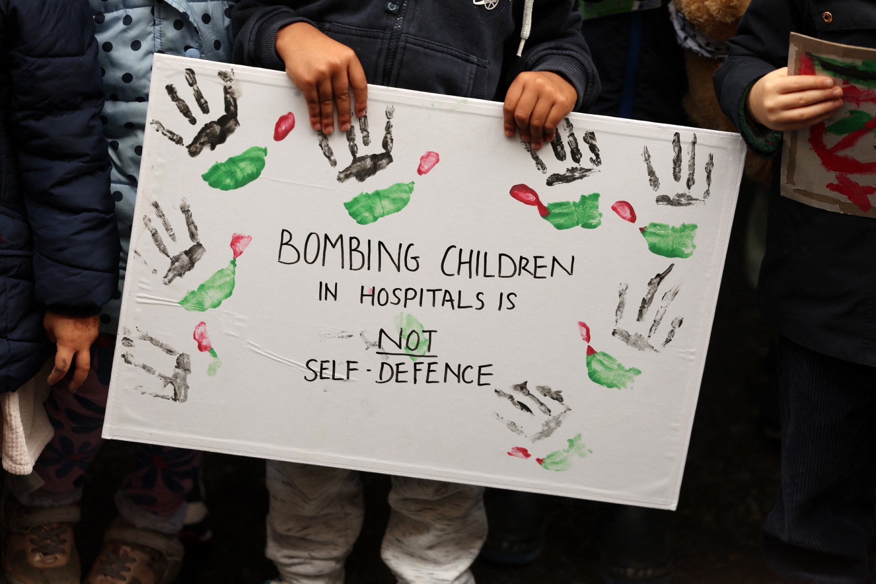 A child holds a placard at a protest outside the Foreign, Commonwealth and Development Office in London on October 27, 2023, organised by Parents for Palestine calling for the UK government to withdraw its support for Israel. (AFP)