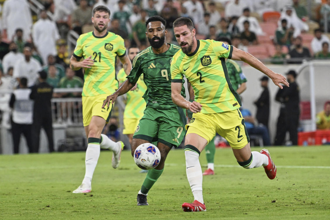 Saudi Arabia’s Feras Albrikan, center, is challenged by Australia’s Milos Degenek, right, during the World Cup 2026 Group C qualifying soccer match. (AP)