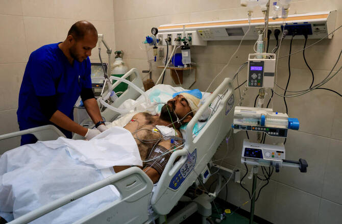 Hamdi Al-Najjar in a hospital bed in the Intensive Care Unit at Nasser Hospital before he died from his injuries from an Israeli strike that also killed his nine children. (Reuters)