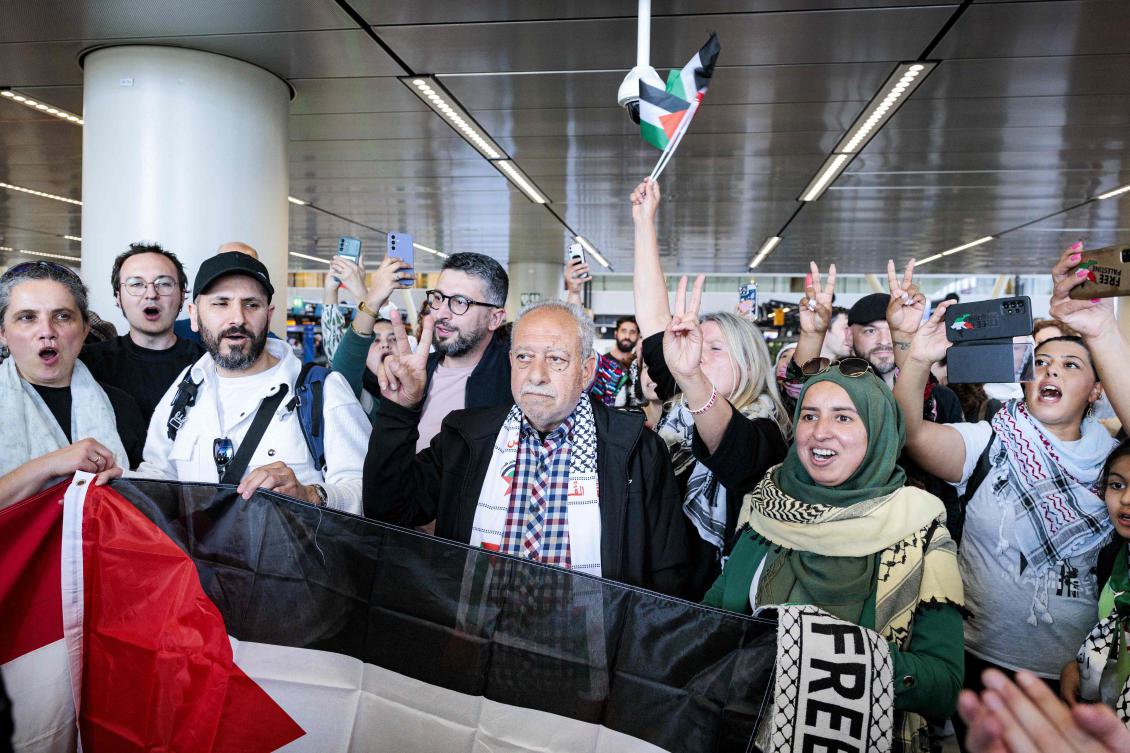 Participants in the March to Gaza flash the victory sign as they depart from Schiphol Airport for Egypt, on Wednesday. (AFP)