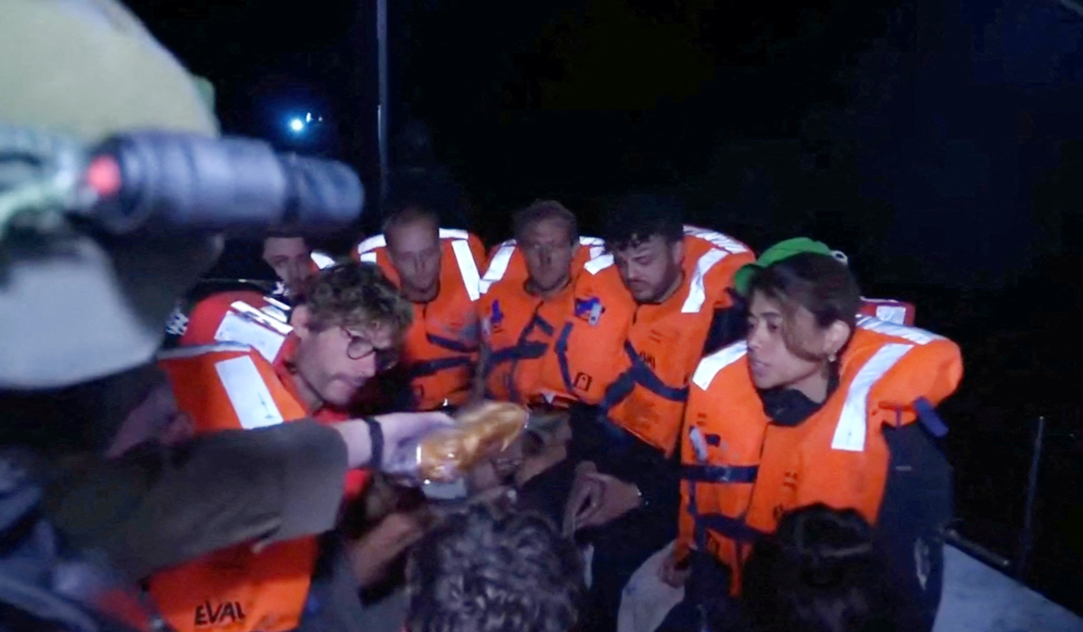 An Israeli solider passes food to those onboard the Gaza-bound British-flagged yacht "Madleen" after Israeli forces boarded the charity vessel as it attempted to reach the Gaza Strip in defiance of an Israeli naval blockade, in this screengrab from video released on June 9, 2025. (REUTERS)