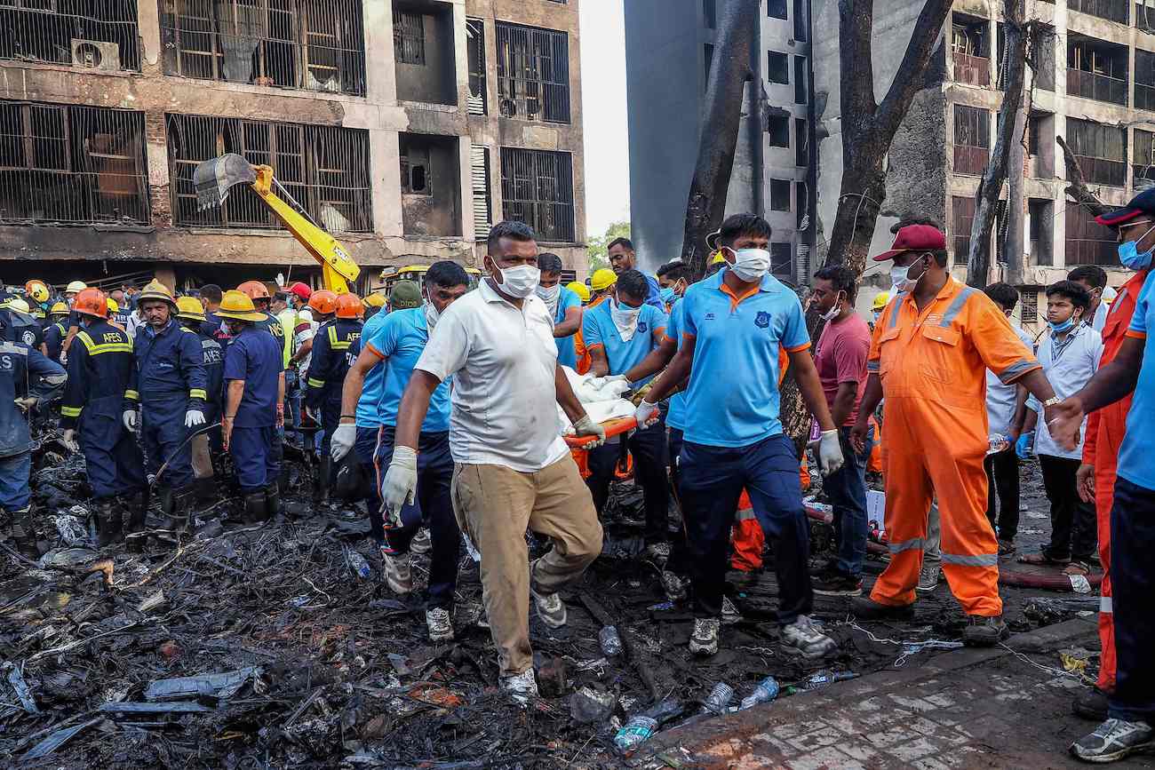 Rescue officials carry a victim’s body at the site where Air India flight 171 crashed in a residential area near the airport in Ahmedabad on June 12, 2025. (AFP)