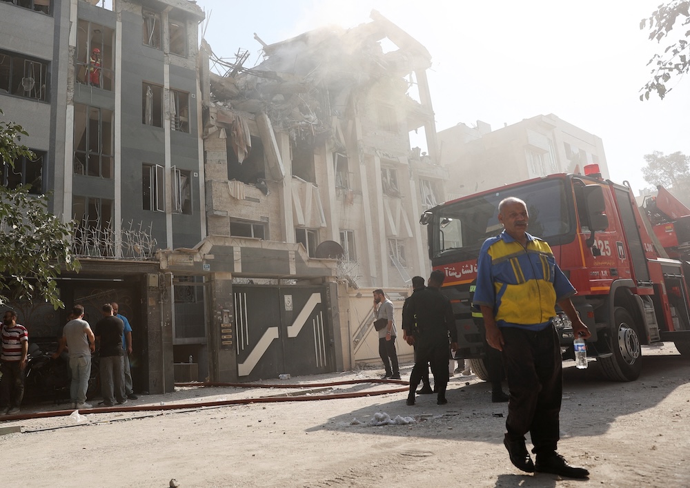 Rescuers work at the scene of a damaged building in Tehran in the aftermath of Israeli strikes on June 13, 2025. (West Asia News Agency via Reuters)