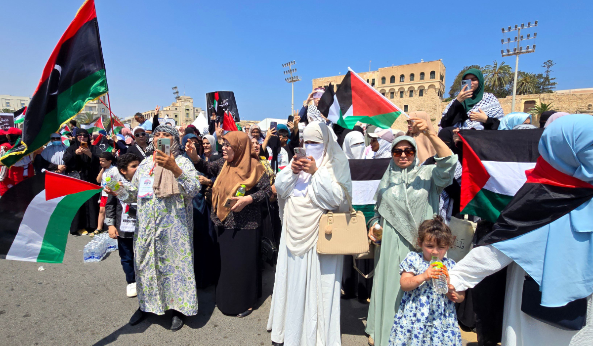 Libyans wave flags as they greet activists, heading towards Gaza by land with the aim of breaking the siege on the Palestinian territory, in Tripoli's Martyrs Square on June 11, 2025, one day after crossing into Libya from Tunisia. (AFP)