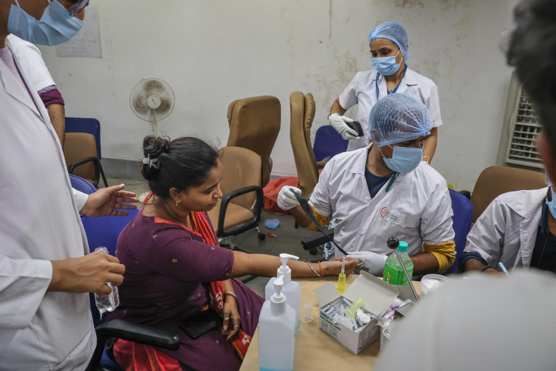 Doctors collect a DNA sample from a relative of a victim, who died in the Air India crash, who came to claim the body at Civil Hospital in Ahmedabad, Gujarat on June 13, 2025. (EPA)