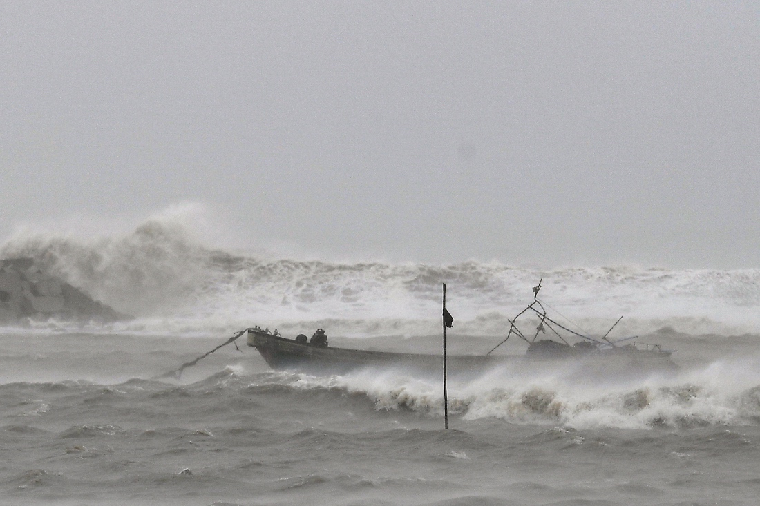 A fishing boat is moored to take shelter from Typhoon Wutip in the waters near a waterfront square in Yinggehai Town, China. (Xinhua)