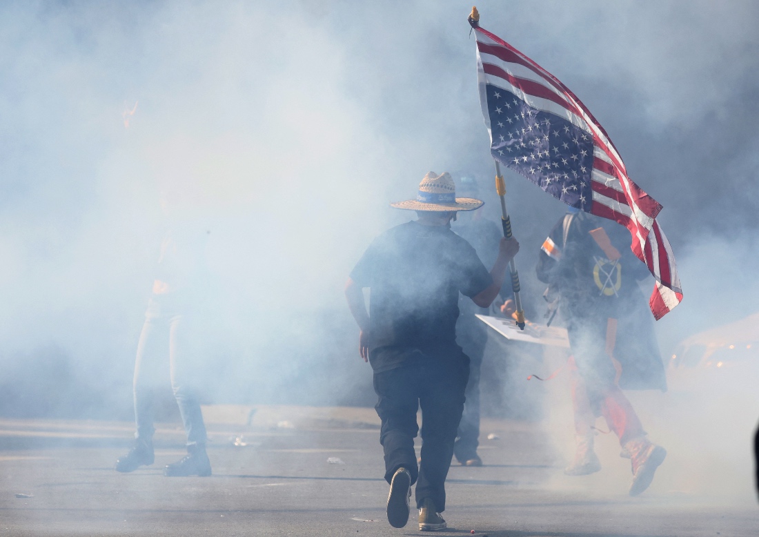 A demonstrator runs amid tear gas during a "No Kings" protest against President Trump's policies in California, US. (Reuters)