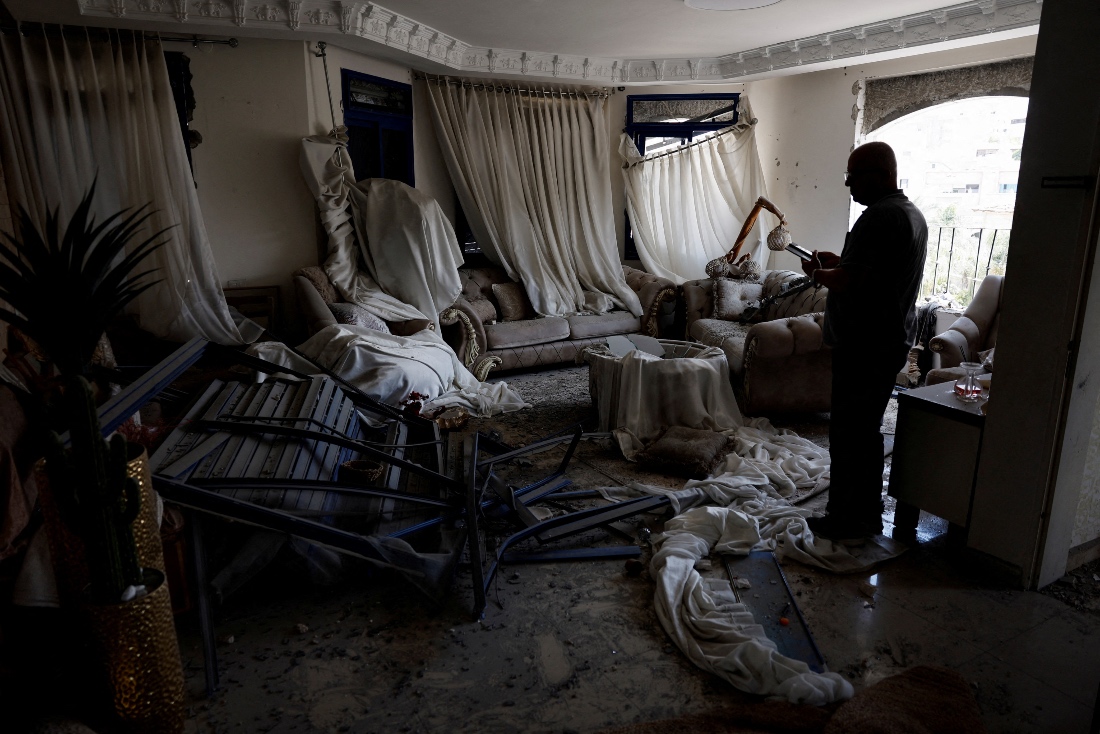 A man stands inside a damaged room after missiles fired from Iran hit a residential building in Tamra, Israel. (Reuters)