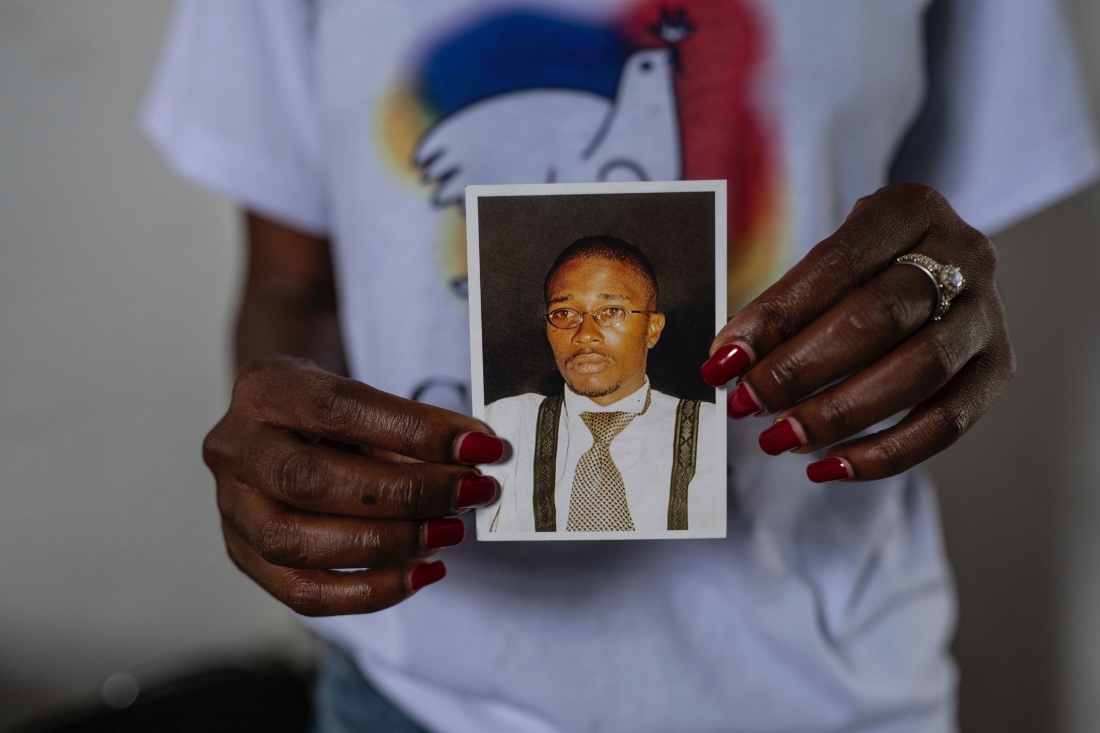 A woman holds holds a photo of Floribert Bwana Chui Bin Kositi in Goma, DRC. (AP)