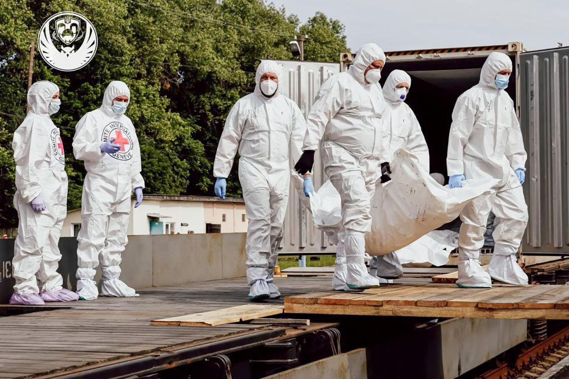 Employees of the International Committee of the Red Cross unload what are reported to be the bodies of Ukrainian citizens, including military personnel, returned by Russia on June 15, 2025. (Coordination Headquarters for the Treatment of Prisoners of War/AFP)