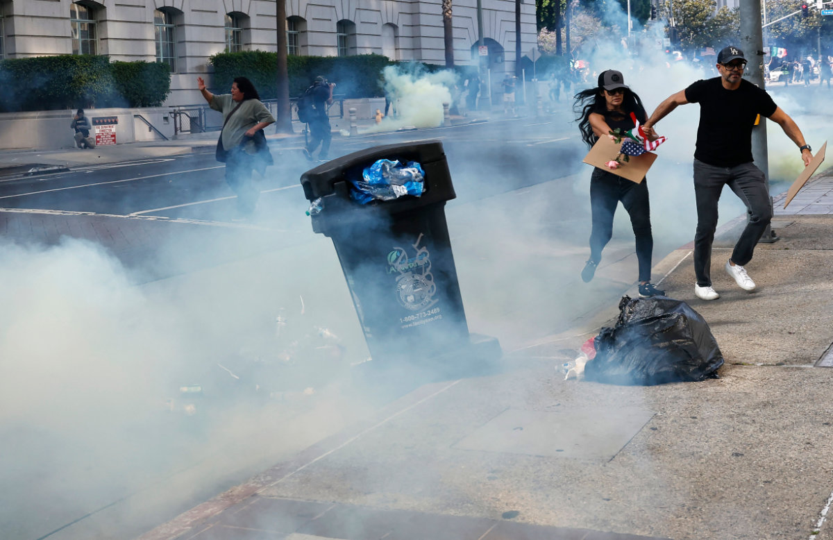 Protesters run from tear gas as police clear a street of demonstrators in front of City Hall after an "unlawful assembly" was declared on June 14, 2025 in Los Angeles, California. (Getty Images via AFP)