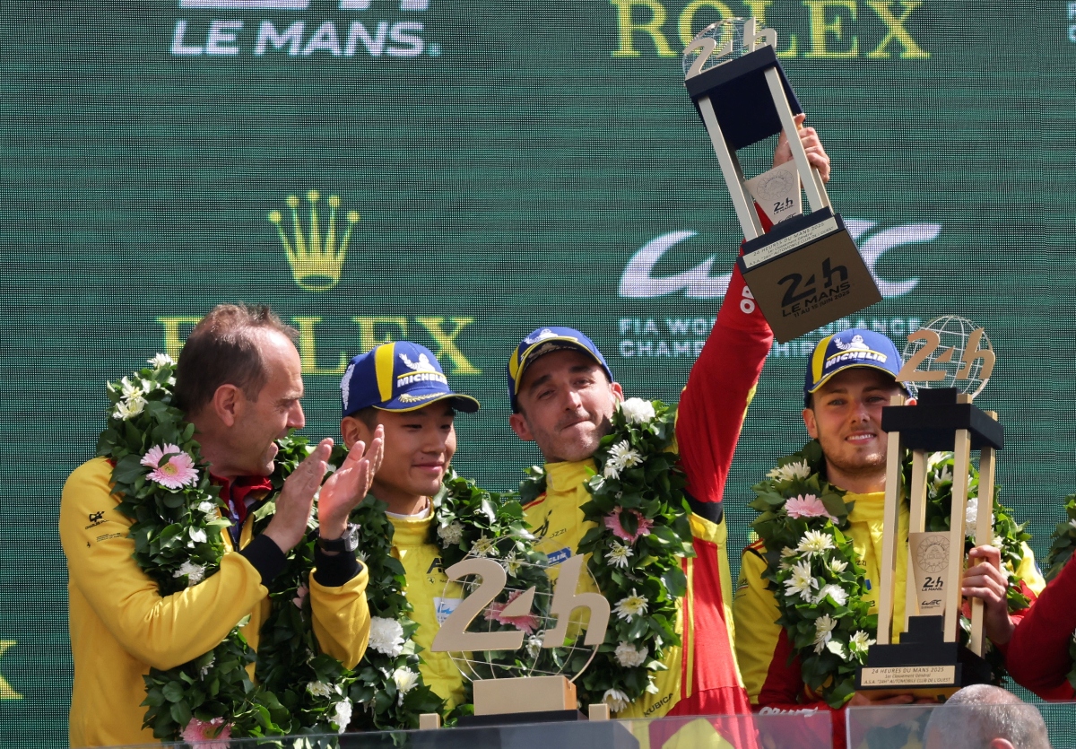 AF Corse’s Robert Kubica, Yifei Ye and Philip Hanson celebrate with their medals and trophy on the podium after winning the 24 Hours of Le Mans along with team principal Amato Ferrari on Sunday. (Reuters)