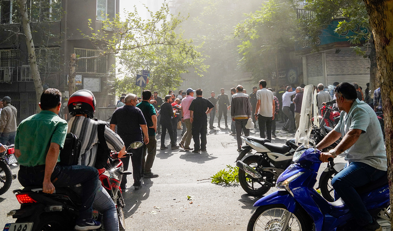 People gather in the street amid smoke following the Israeli strikes on Iran, in Tehran, Iran, on June 15, 2025. (Wana News Agency/File)