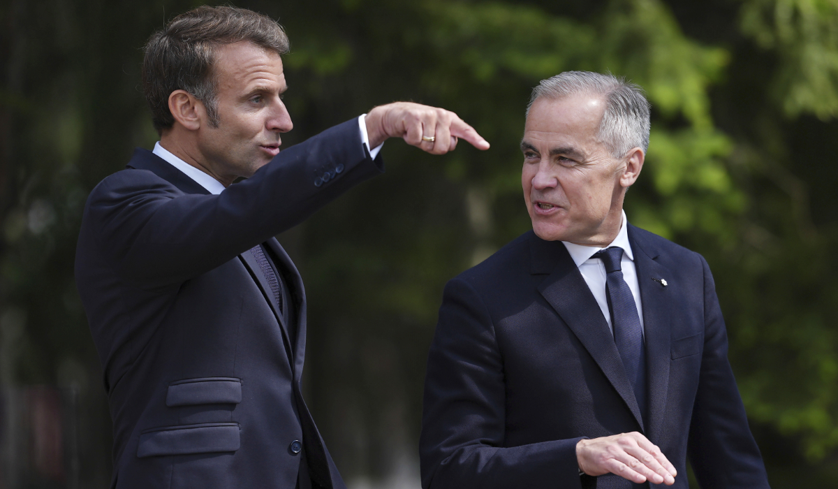 French President Emmanuel Macron, left, and Canadian Prime Minister Mark Carney walk to a meeting after officially welcoming Macron to the G7 Summit in Kananaskis, Alberta, Canada, Monday, June 16, 2025. (AP)