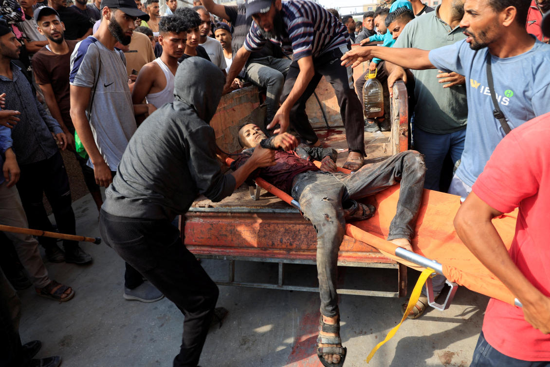 Palestinians carry a man who was wounded in an Israeli strike while waiting for aid, according to the Gaza Health Ministry, at Nasser hospital, in Khan Younis, southern Gaza Strip, June 17, 2025. (Reuters)