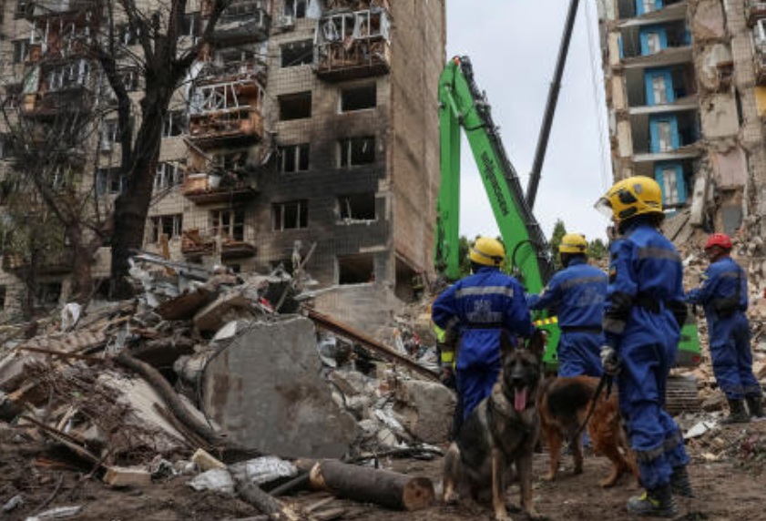 Rescuers with service dogs prepare to look for residents, who could still be under the rubble of a destroyed apartment building, which was hit during a Russian missile strike in Kyiv, Jun. 17, 2025. (Reuters)