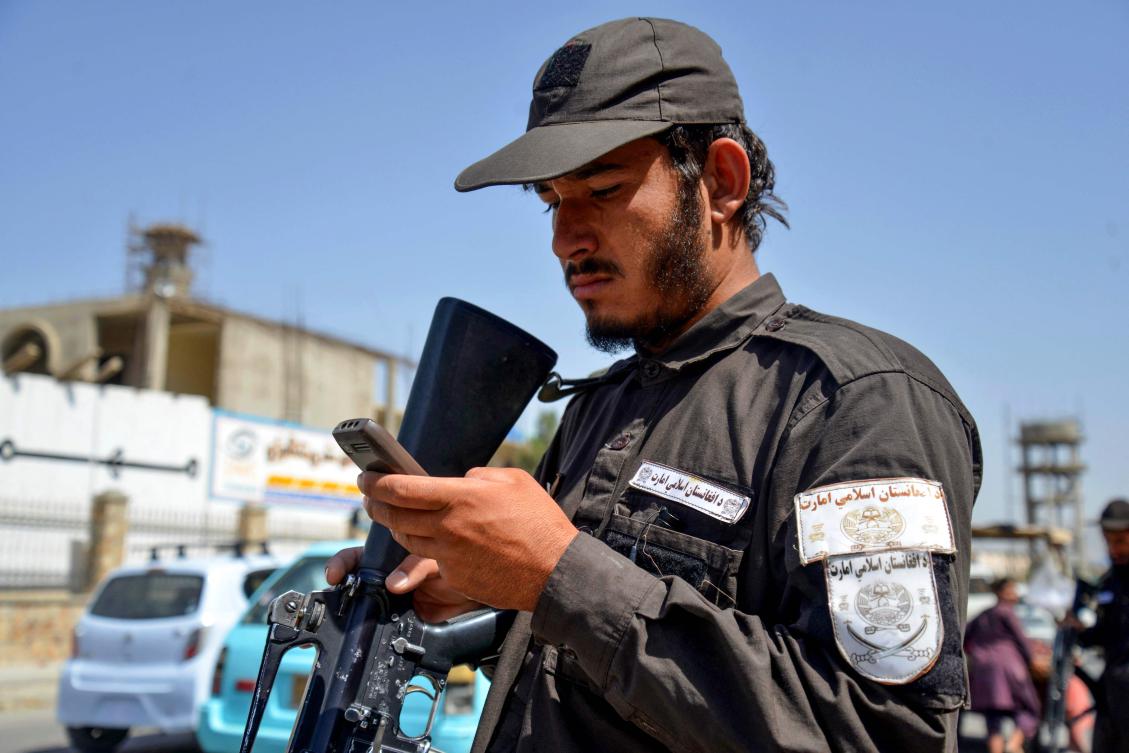 A Taliban security personnel uses a non-smartphone along a road in Kandahar on June 17, 2025. (AFP)