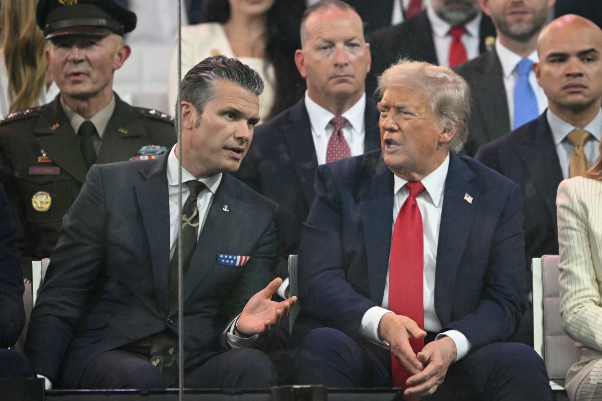 US President Donald Trump speaks to US Secretary of Defense Pete Hegseth as they watch the Army 250th Anniversary Parade from the Ellipse in Washington, DC, June 14, 2025. (AFP)