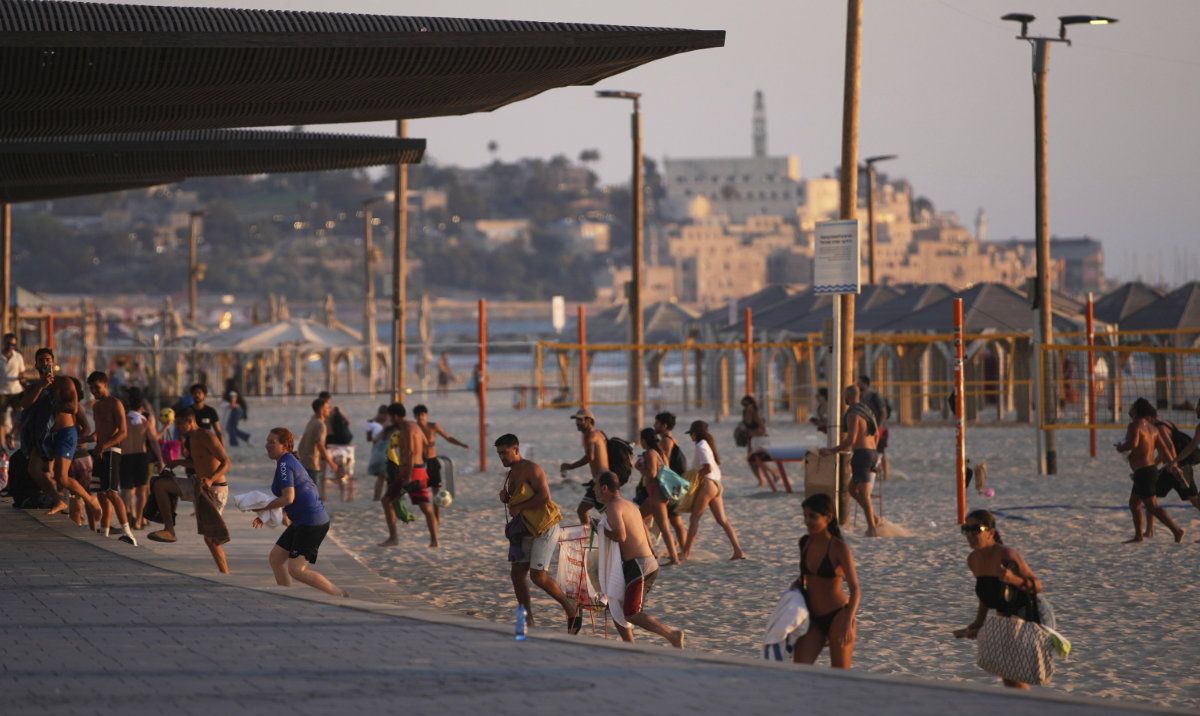 Beachgoers leave during a missile alert from Iran, in Tel Aviv, Israel, Wednesday, June 18, 2025. (AP)
