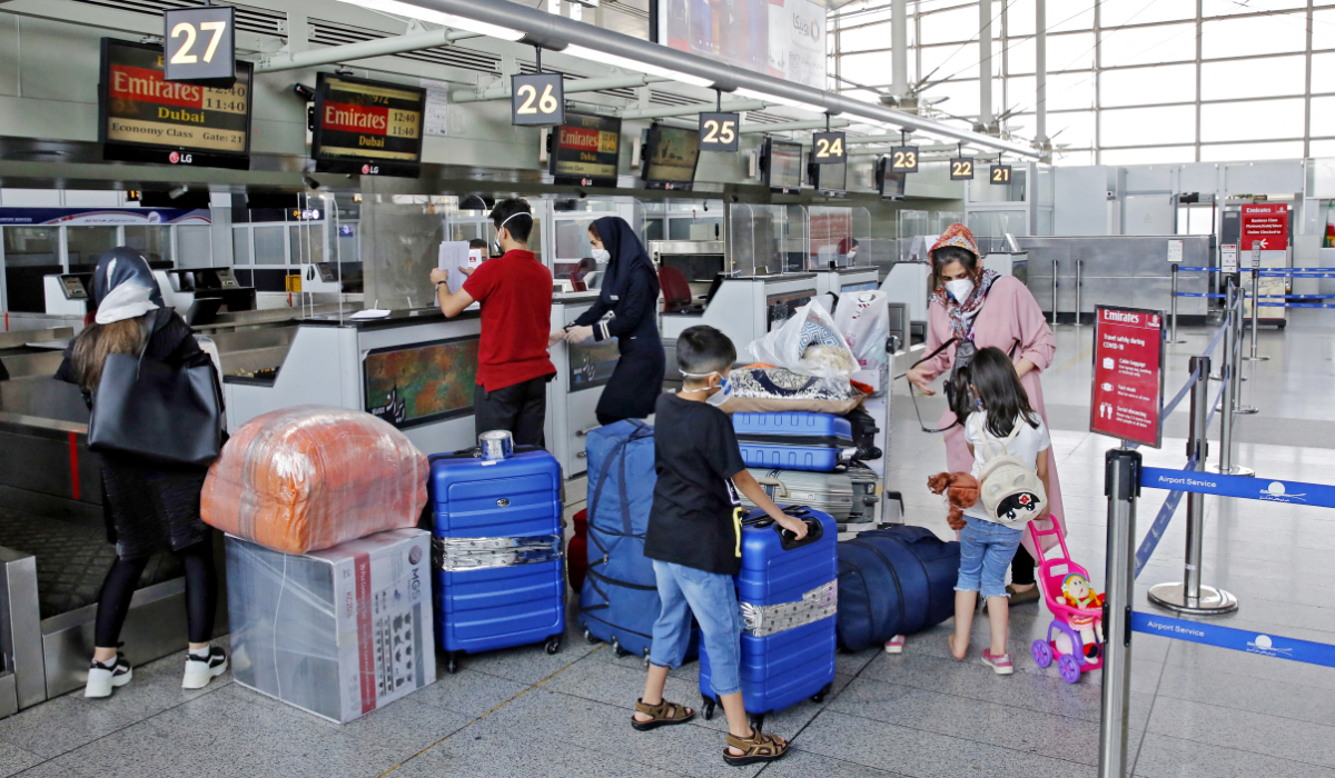 Outbound passengers arrive with their luggage at the Emirates check-in counter at the Iranian capital Tehran's Imam Khomeini International Airport on July 17, 2020. (AFP)
