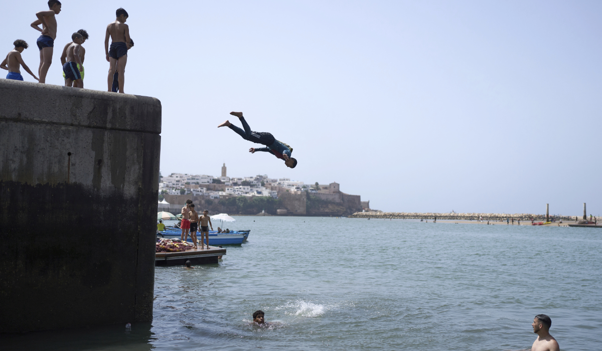 Boys jump into a river to cool down during a hot sumer day, in Rabat, Morocco, Friday, June 20, 2025. (AP)