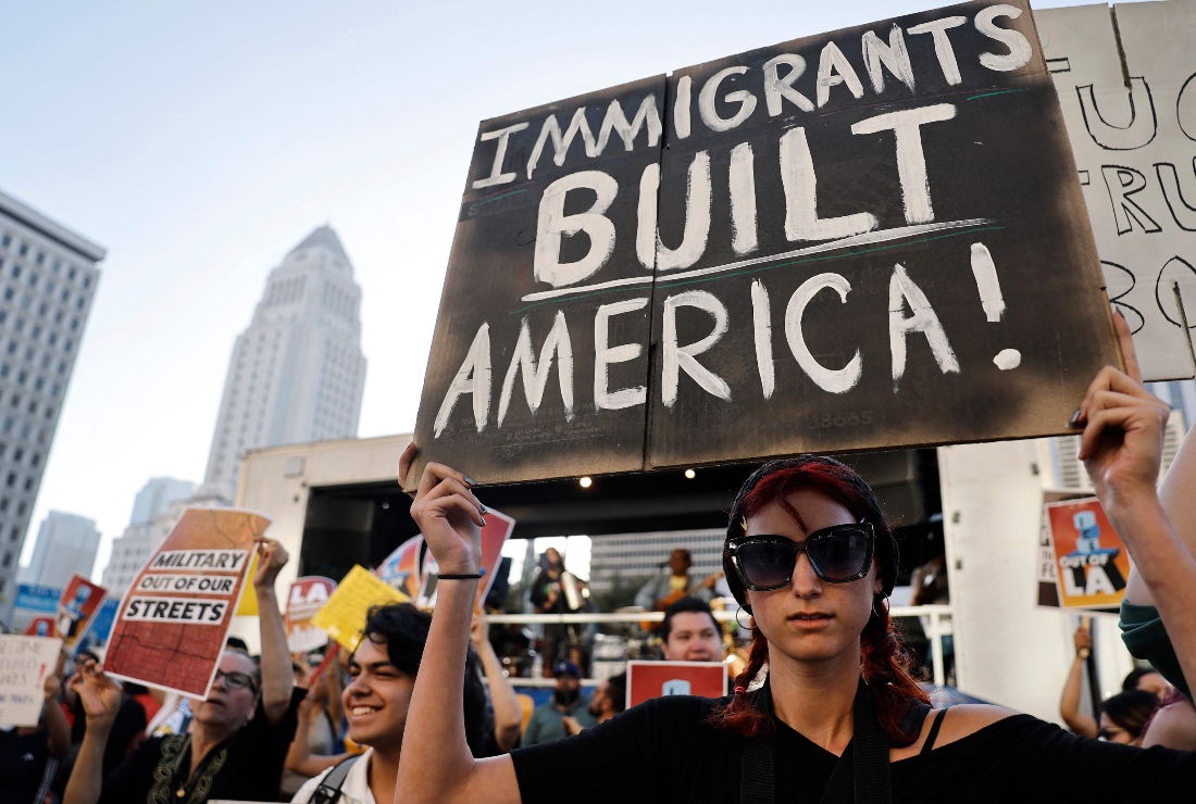 Protestor holds sign sparked By Federal Immigration Raids in LA, US. (AFP)