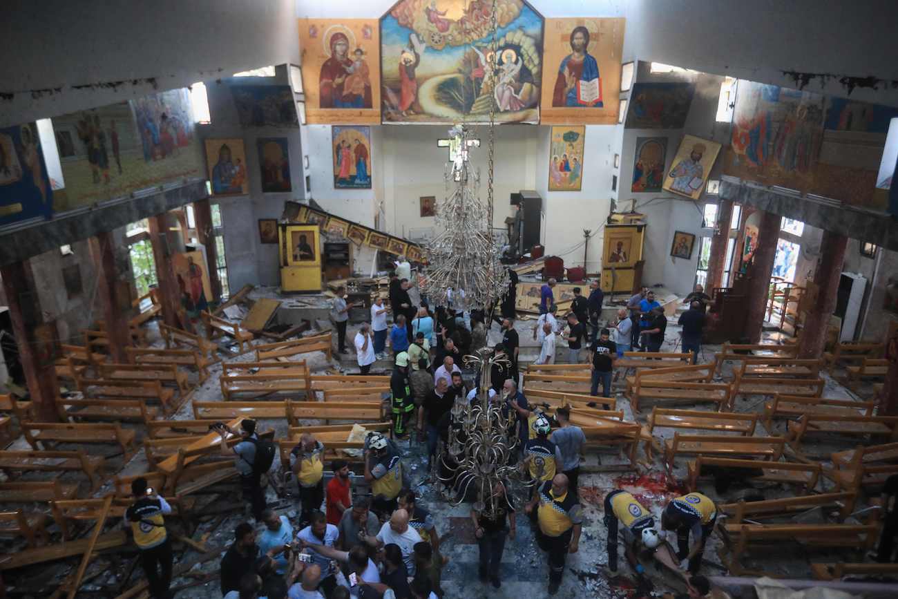 People and rescuers inspect the damage at the site of a reported suicide attack at the Saint Elias church in Damascus’ Dwelaa area on June 22, 2025. (AFP)
