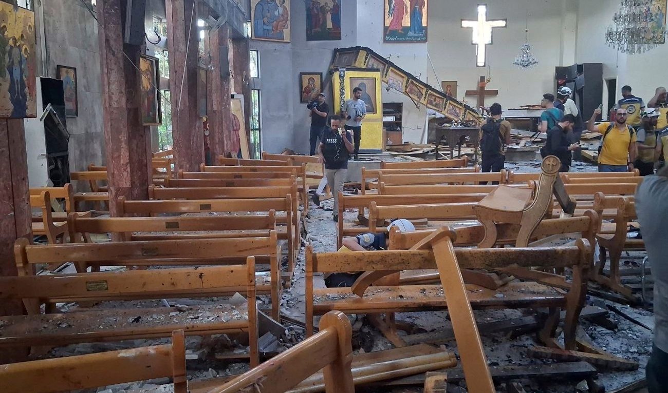 In this photo released by the Syrian official news agency SANA, journalists and Civil Defense workers inspect the damage inside Mar Elias church where a suicide bomber detonated himself in Dweil’a in the outskirts of Damascus, Syria, on June 22, 2025. (SANA)