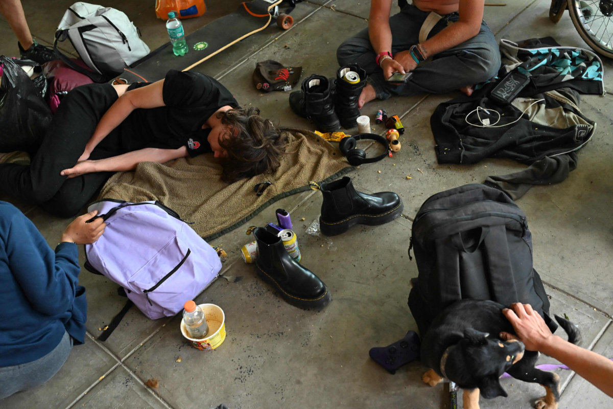 People who identify as homeless gather under the shade of the Boulder Library during high 32-degree Celsius temperatures on June 20, 2025 in Boulder, Colorado. (Getty Images via AFP)