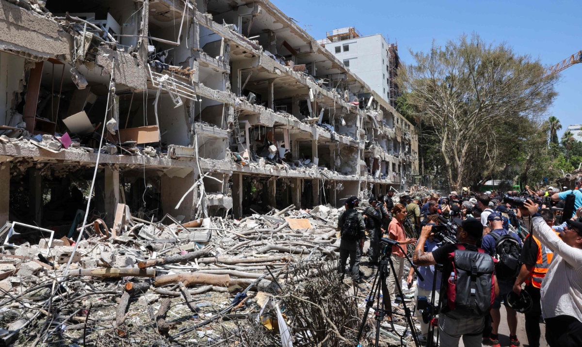 Israeli security forces and media gather at the site of an Iranian strike that hit a residential neighbourhood in the Ramat Aviv area in Tel Aviv on June 22, 2025. (AFP)
