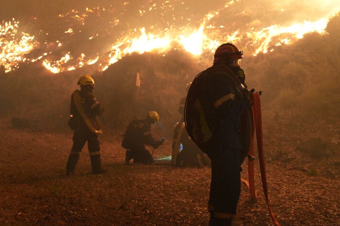 Firefighters battle with a wildfire burning in Kofinas, Greece. (AP)