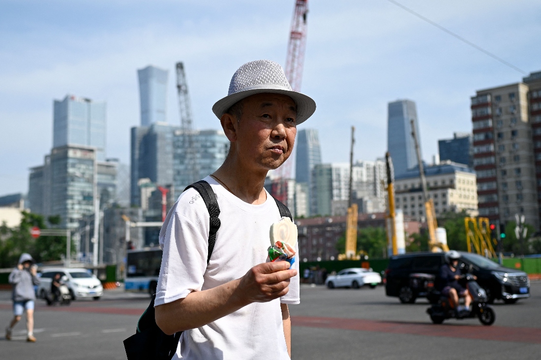 Man holds an ice cream as he crosses the street in Beijing, China. (AFP)