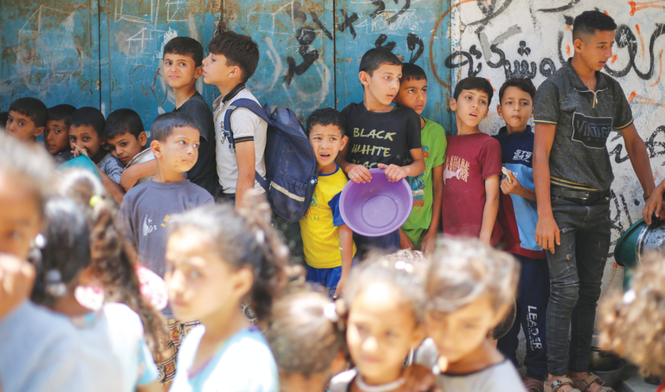 Children queue at a food distribution point in the central Gaza Strip. (AFP)