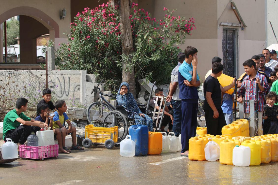 Palestinians queue at a water distribution point in Nuseirat, in the central Gaza Strip, on June 23, 2025. The Israeli blockade imposed in early March amid an impasse in truce negotiations had produced famine-like conditions across Gaza, according to rights groups. (AFP)