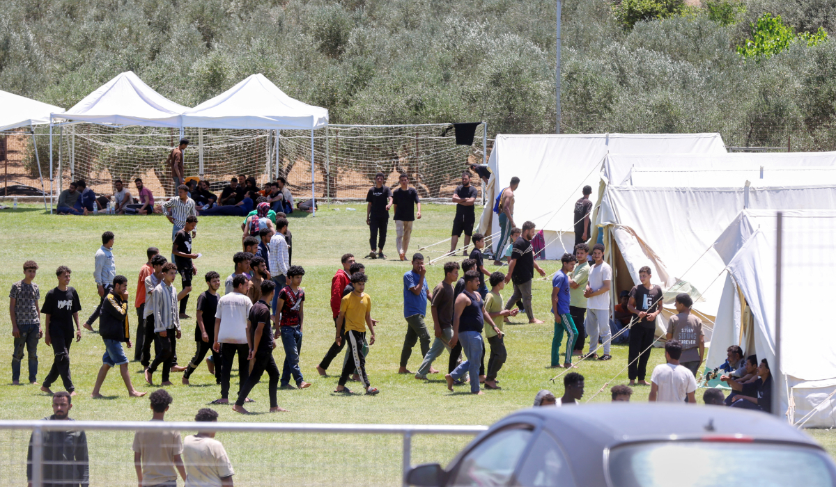 Migrants walk by tents at the temporary migrant’s camp staged on a soccer pitch in the region of Rethymno in Crete island, Greece, June 24, 2025. (REUTERS)