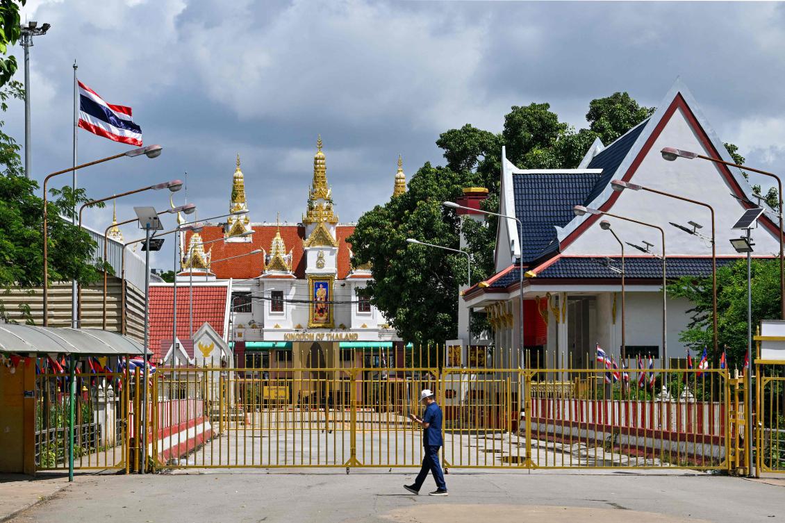A man walks near the closed gate at Poipet International border checkpoint between Cambodia and Thailand, at Poipet town in Banteay Meanchey province on June 25, 2025. (AFP)