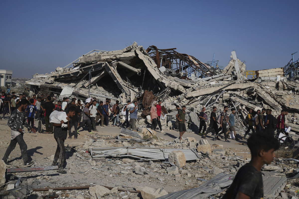 Palestinians carry aid packages from a distribution center in Gaza Thursday. Members of the largest representative body for Jews in the UK have been disciplined for criticizing Israel's conduct of the conflict. (AP)
