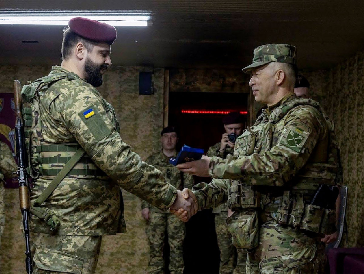 Col. Gen. Oleksandr Syrskyi (C)., Ukraine's military commander, awards a soldier as he visits the front line in Sumy region. (Handout photo via AFP)