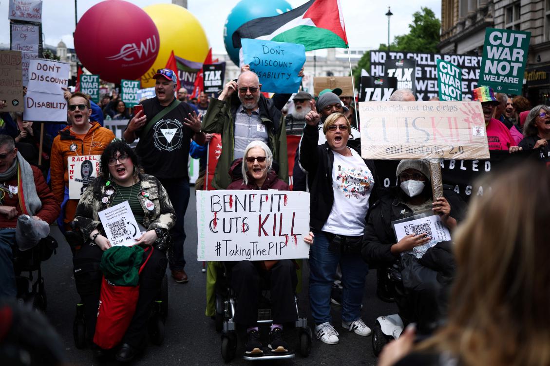 Protesters hold placards as they take part in a ‘No More Austerity 2.0’ march in central London on June 7, 2025. (AFP)