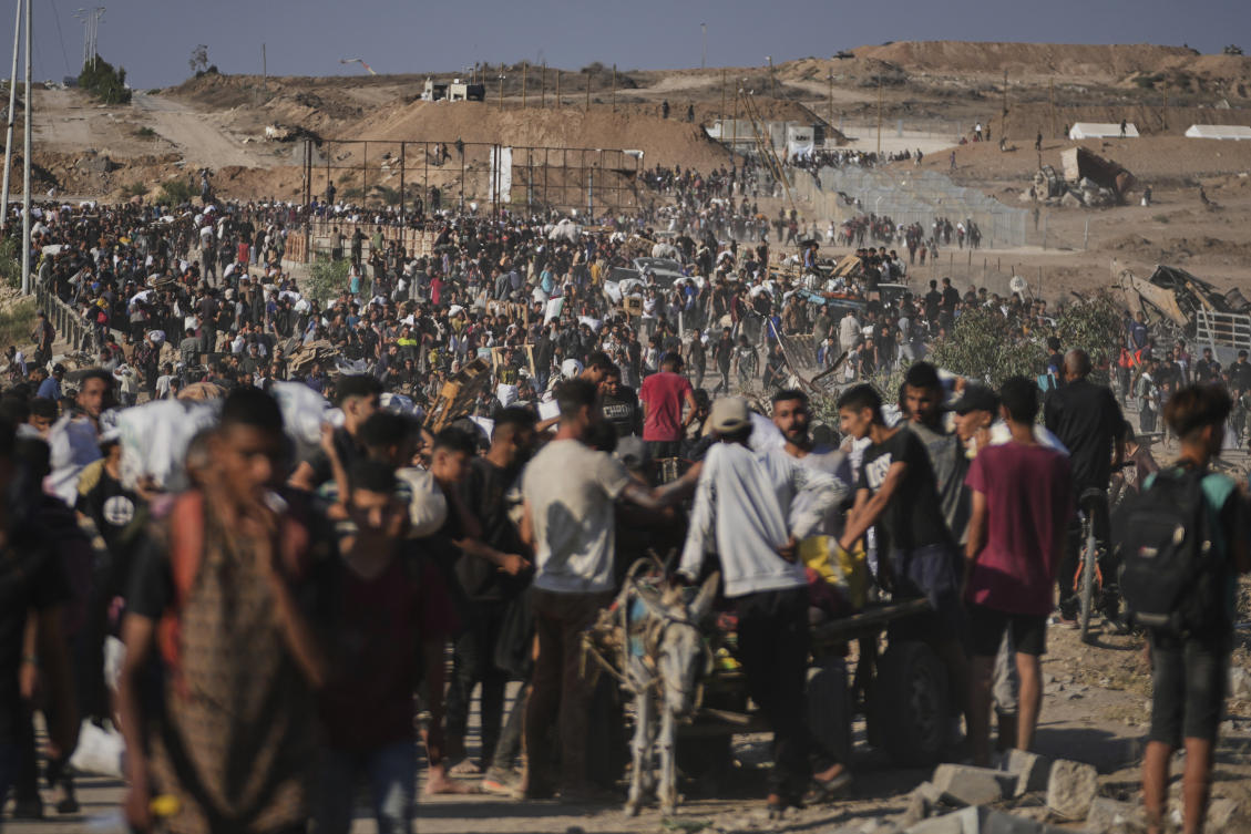 Palestinians carry humanitarian aid packages near the Gaza Humanitarian Foundation distribution center in Khan Younis, Gaza, on Thursday. (AP)