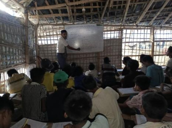 Arif Salam, a Rohingya teacher at a community school in a refugee camp in Cox's Bazar, Bangladesh gestures at a white board during a class. (Supplied by Arif Salam)
